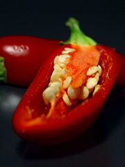 A ripe red jalapeÃ±o cut open to show the seeds