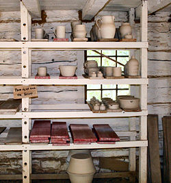 Unfired "green ware" pottery on a traditional drying rack at Conner Prairie living history museum.